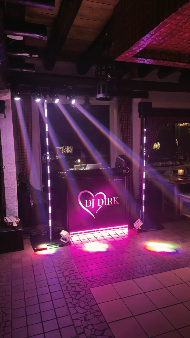 DJ Dirk mit Ambientebeleuchtung und Lichtshow auf einer Tanzfläche in einer Eventlocation mit pinken Lichteffekten