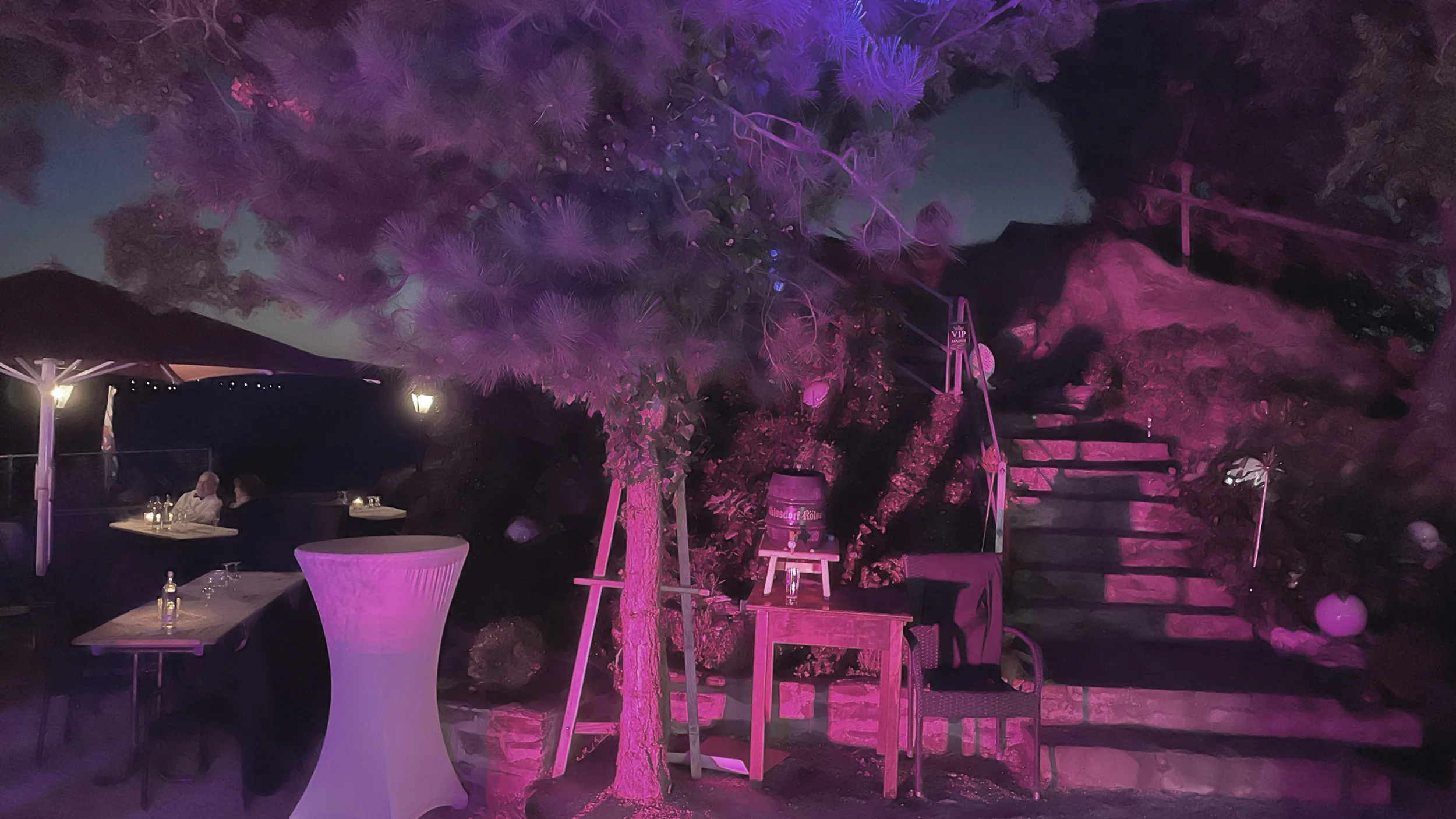 Atmosphärisches Event-Setting im Außenbereich mit dekorativer Beleuchtung und Stehtischen